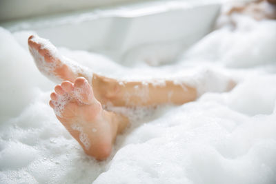 Close-up of feet in bathtub