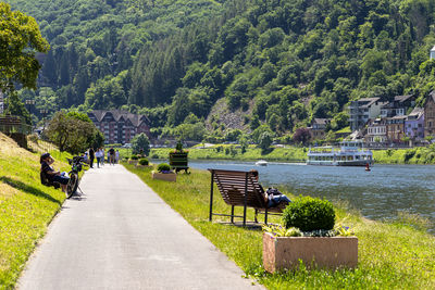 Cochem, germany, june 13, 2021. people sitting on benches along the river.