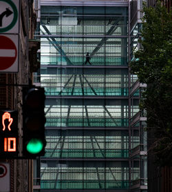 Low angle view of road signs against buildings in city