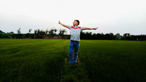 Full length of young woman standing on field