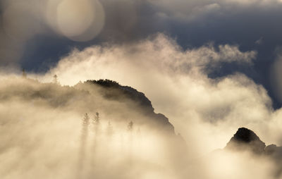 Low angle view of mountains against cloudy sky