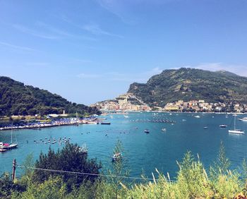 Scenic view of sea by mountains against sky