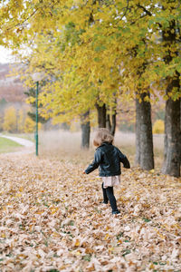 Rear view of woman walking on field