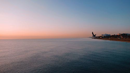 Scenic view of sea against clear sky during sunset