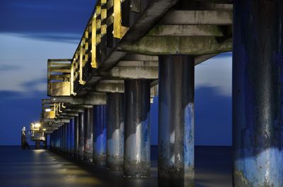 View of bridge over calm sea at night