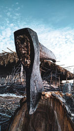 Close-up of old wooden log against sky