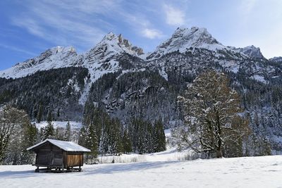 Built structure on snow covered mountain against sky