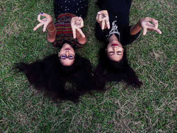 High angle view of female friends lying on grass