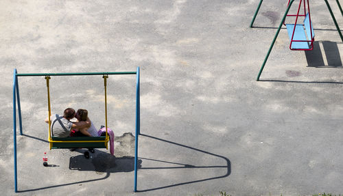 High angle view of couple kissing on swing