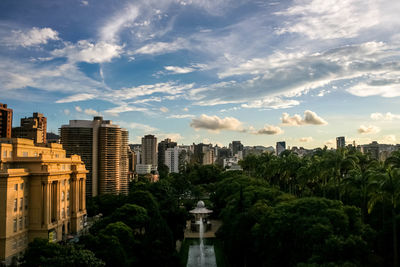 High angle view of trees growing by city against sky