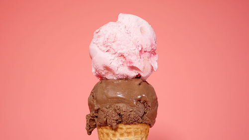 Close-up of ice cream cone against pink background