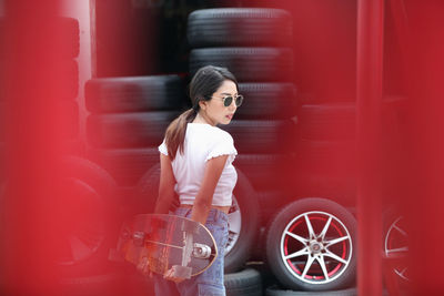 Full length portrait of young woman standing in car