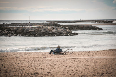 Man with the bicycle contemplates the sea