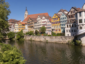 Buildings by river in town against sky