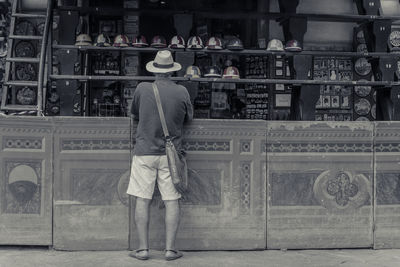 Rear view of man standing at shop in market