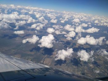 Aerial view of clouds over landscape seen from airplane