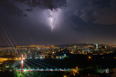 Aerial view of illuminated city against sky at night