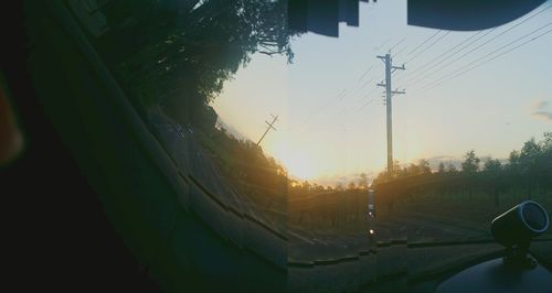 Trees and electricity pylon against sky during sunset