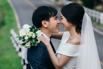 Close-up of newlywed couple embracing outdoors