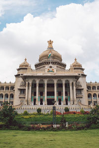 Facade of historical building against cloudy sky