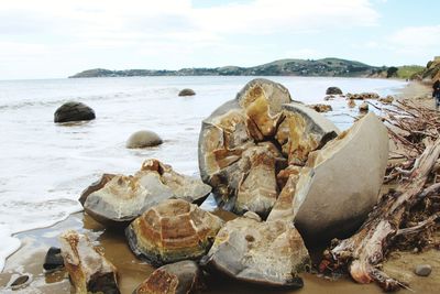 Rocks on beach against sky