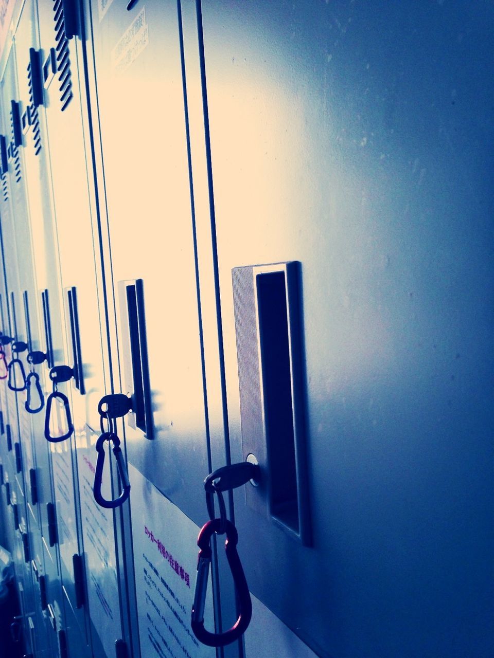 blue, wall - building feature, low angle view, indoors, wall, no people, in a row, built structure, copy space, metal, electricity, architecture, lighting equipment, hanging, close-up, day, sunlight, shadow, absence