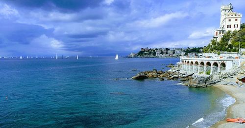 View of buildings in sea against cloudy sky