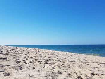 Scenic view of beach against clear blue sky