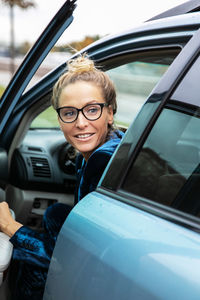 Portrait of young woman sitting in car