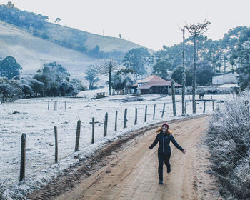 Rear view of man walking on road