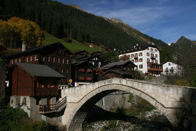 Houses by mountain against sky