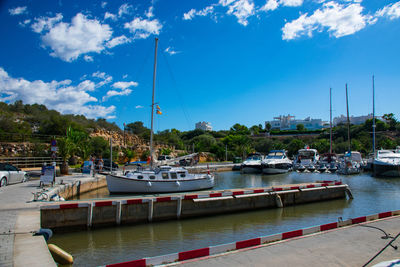 Boats moored at harbor against sky