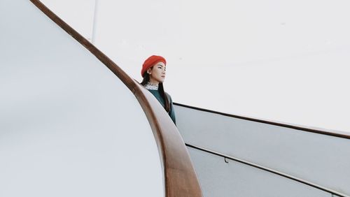 Woman looking away against wall