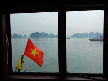 Scenic view of lake against sky seen through window