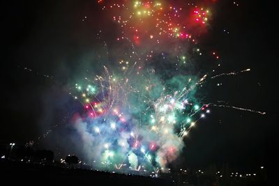 Low angle view of firework display at night