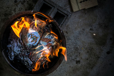 High angle view of money burning in basket