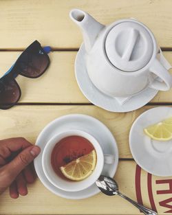 Directly above shot of person holding tea cup on table