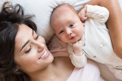 Portrait of cute baby girl lying on bed