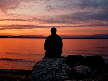 Rear view of man looking at sea against sky