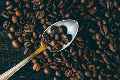 Coffee beans and spoon on table