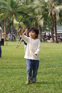 Cute siblings playing with pinwheel at park