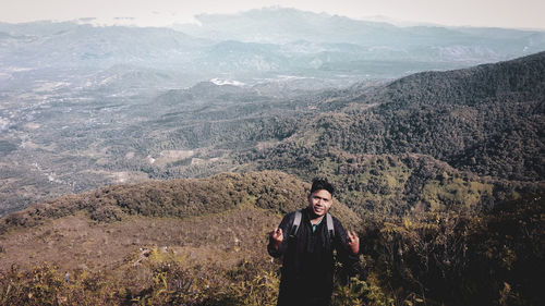 Young man standing against landscape