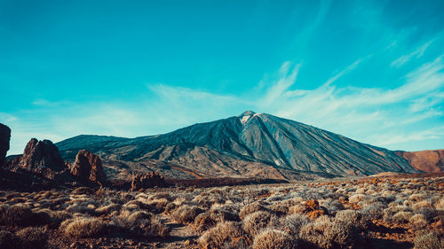 Scenic view of mountain range against blue sky