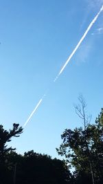 Low angle view of vapor trail in blue sky