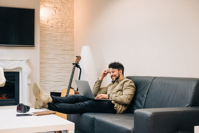 Man using mobile phone while sitting on sofa at home