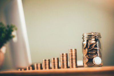 Close-up of coins by laptop on table