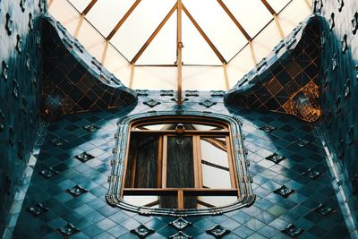 Low angle view of building seen through glass window
