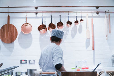Rear view of people working on table