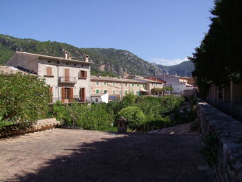 Houses by mountains against clear sky