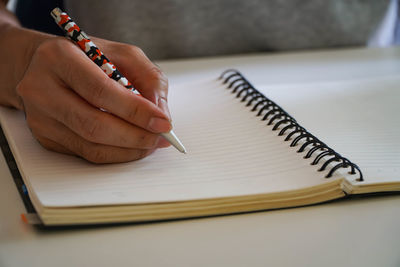 Midsection of woman reading book on table